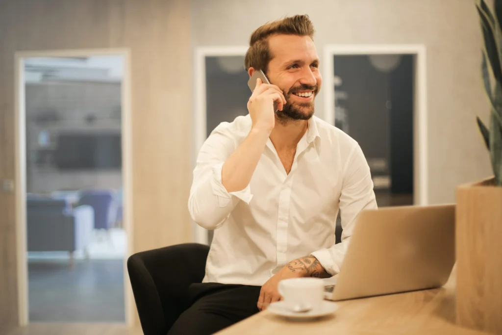 Professionally dressed man smiling while talking on the phone
