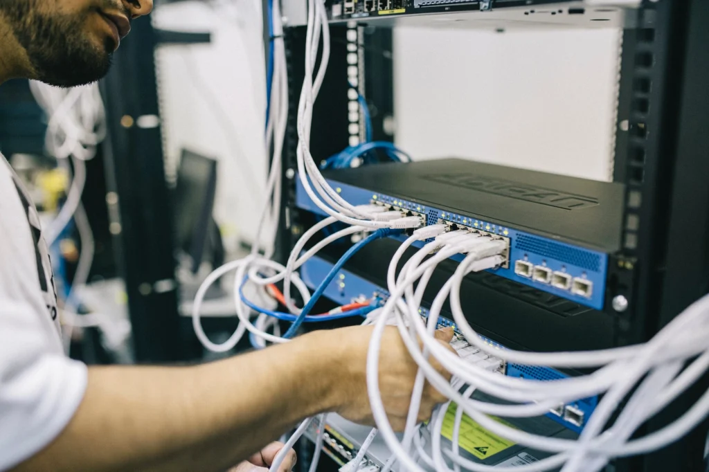Network engineer plugging cables into a network switch